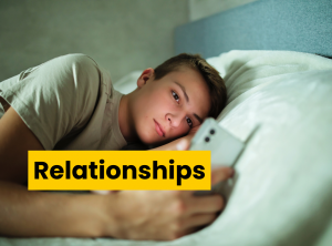 Young man is lying in bed looking at his phone .He has a concerned look on his face.